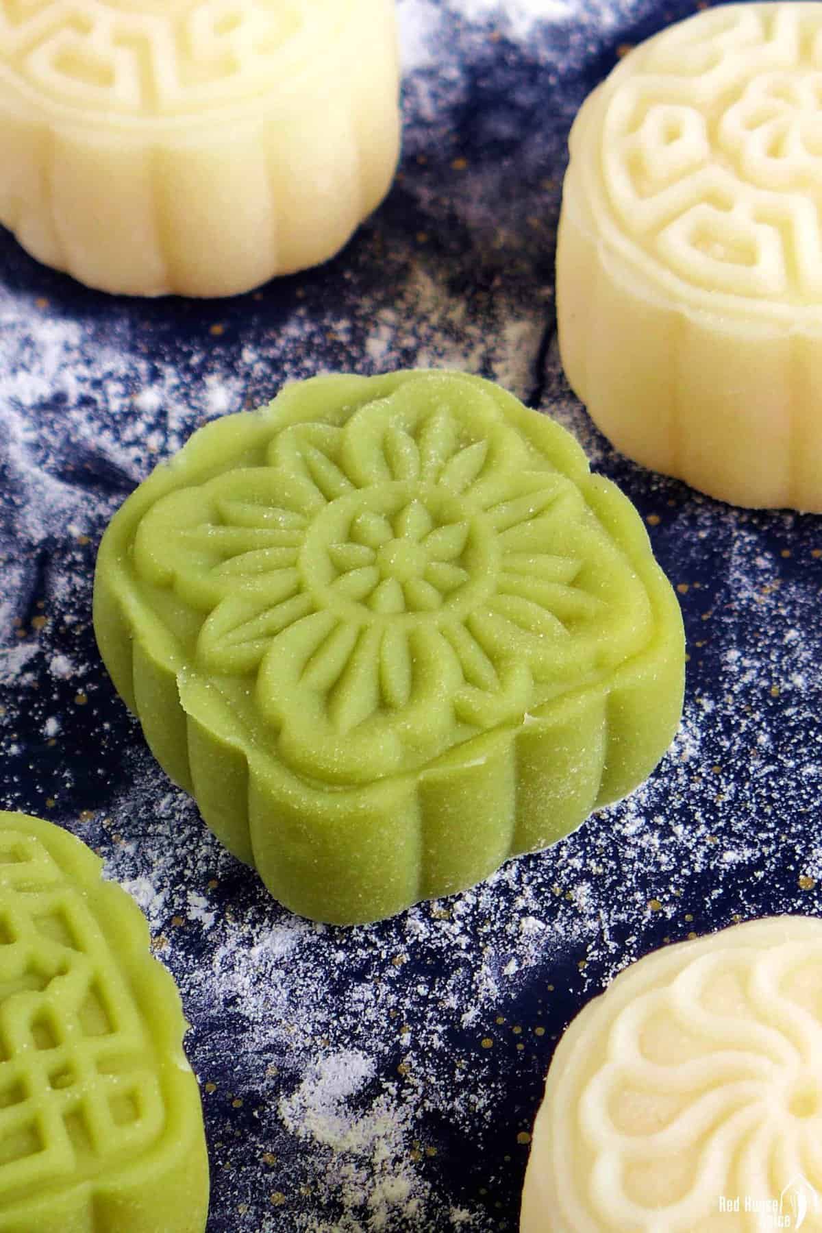 a close up shot of a green snow skin mooncake.