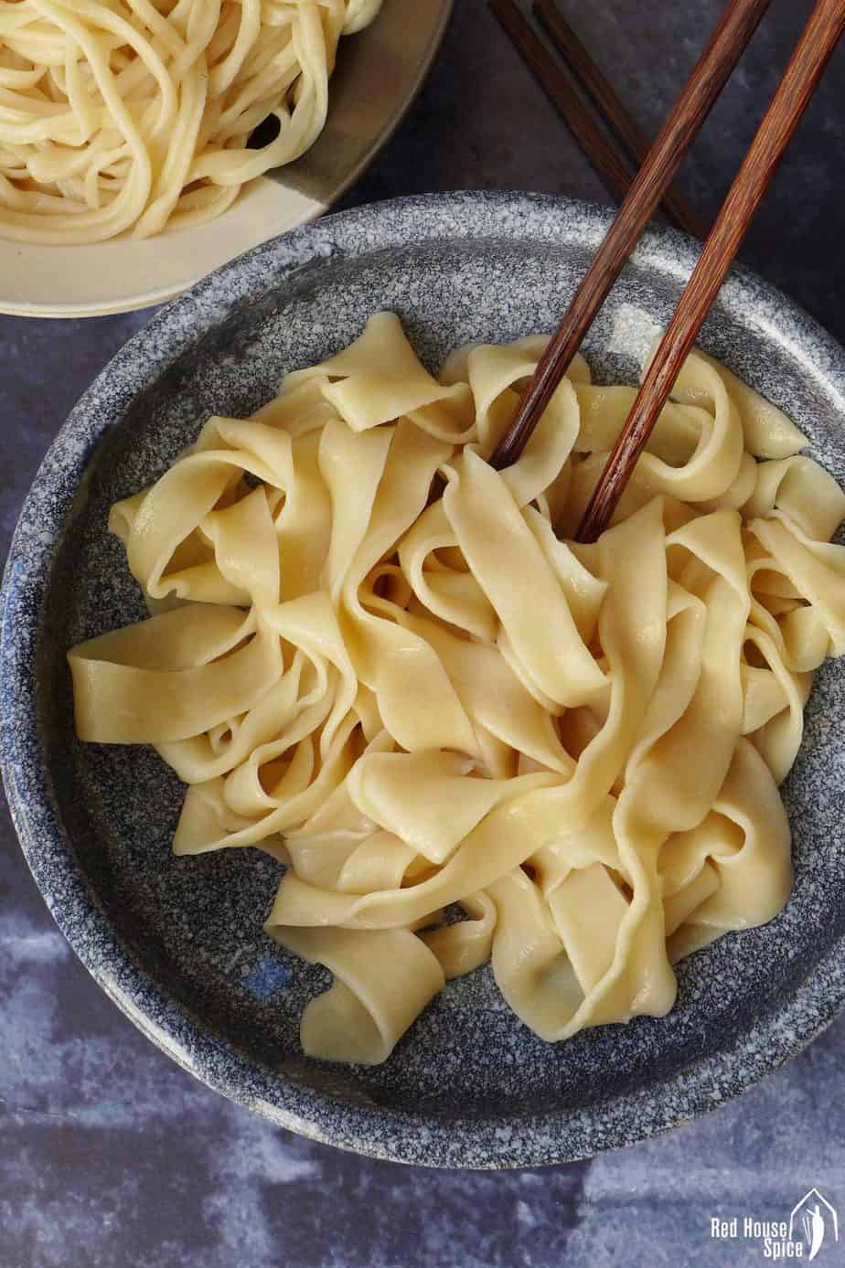 A bowl of plain, wide noodles pulled by hands