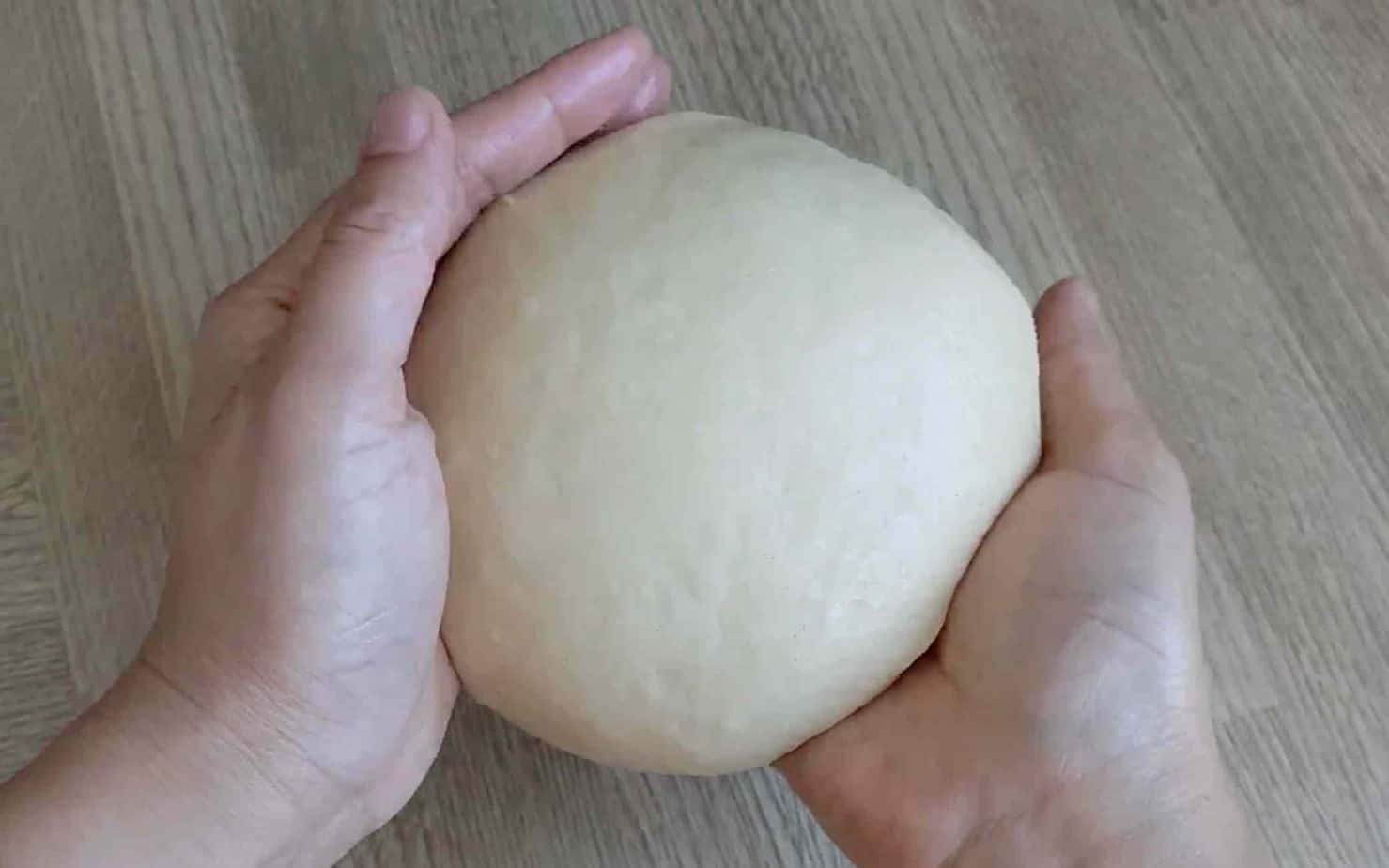 Hands holding a piece of dough