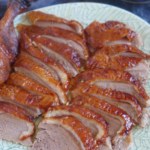 Sliced roast Peking duck with overlay text that says homemade Peking duck