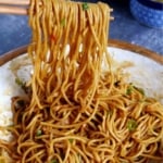 hot dry noodles lifted by chopsticks with overlay text that says hot dry noodles.