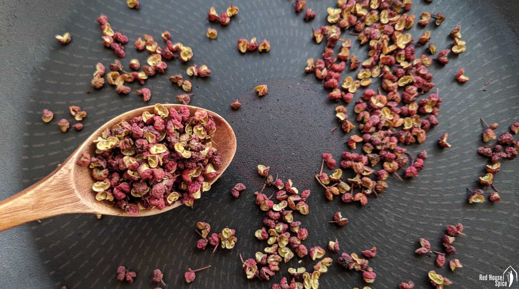 Whole Sichuan peppercorns in a frying pan