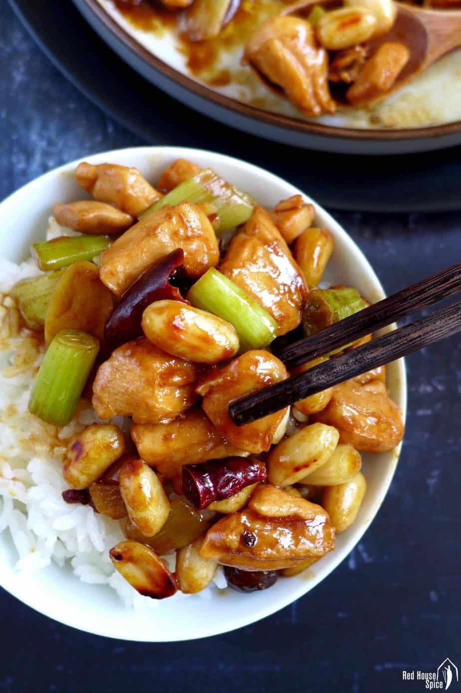 Chopsticks picking up a piece of chicken