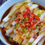A plate of mung bean jelly noodles with overlay text that says spicy jelly noodles.