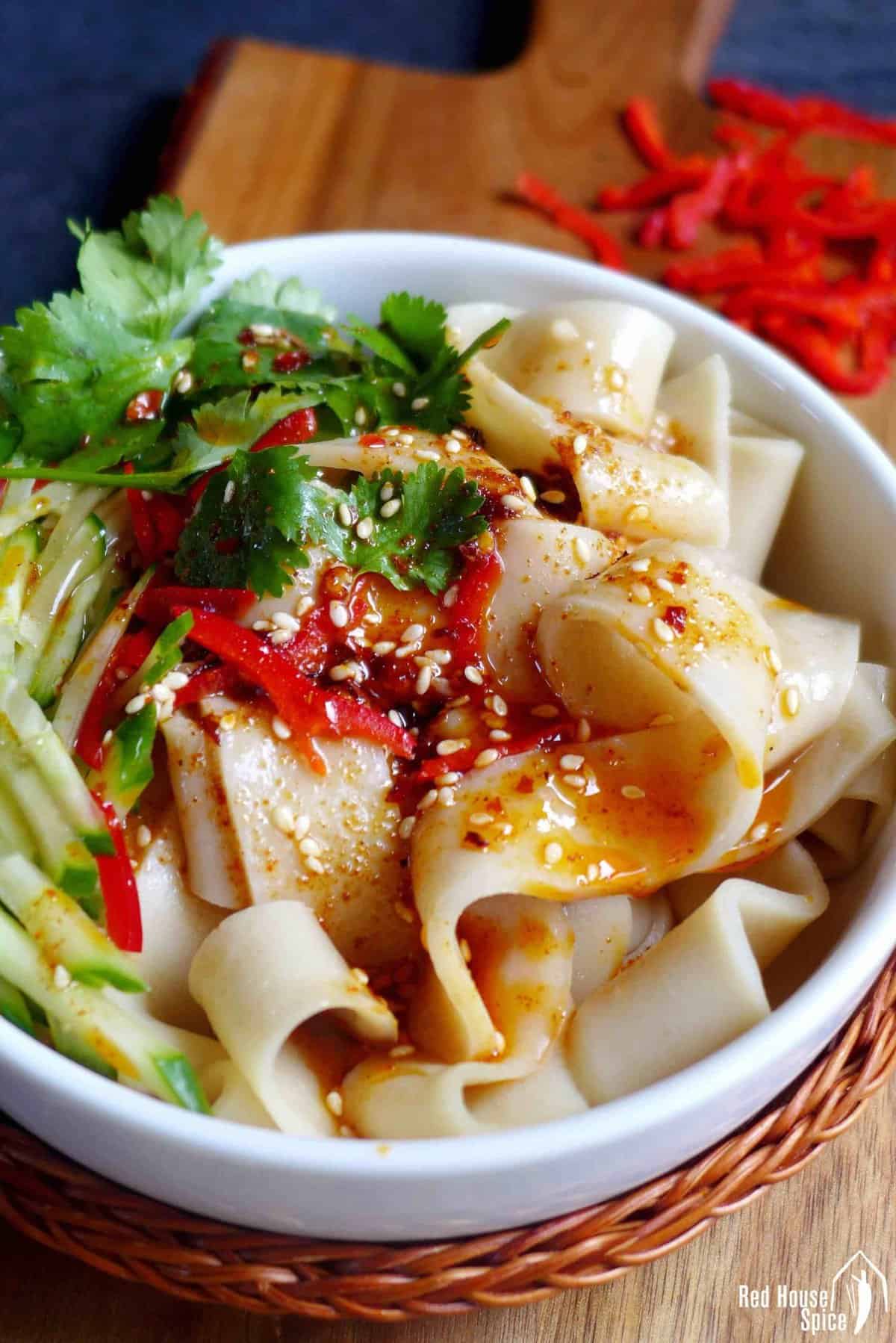 Chinese cold skin noodles with cucumber and spicy dressing.