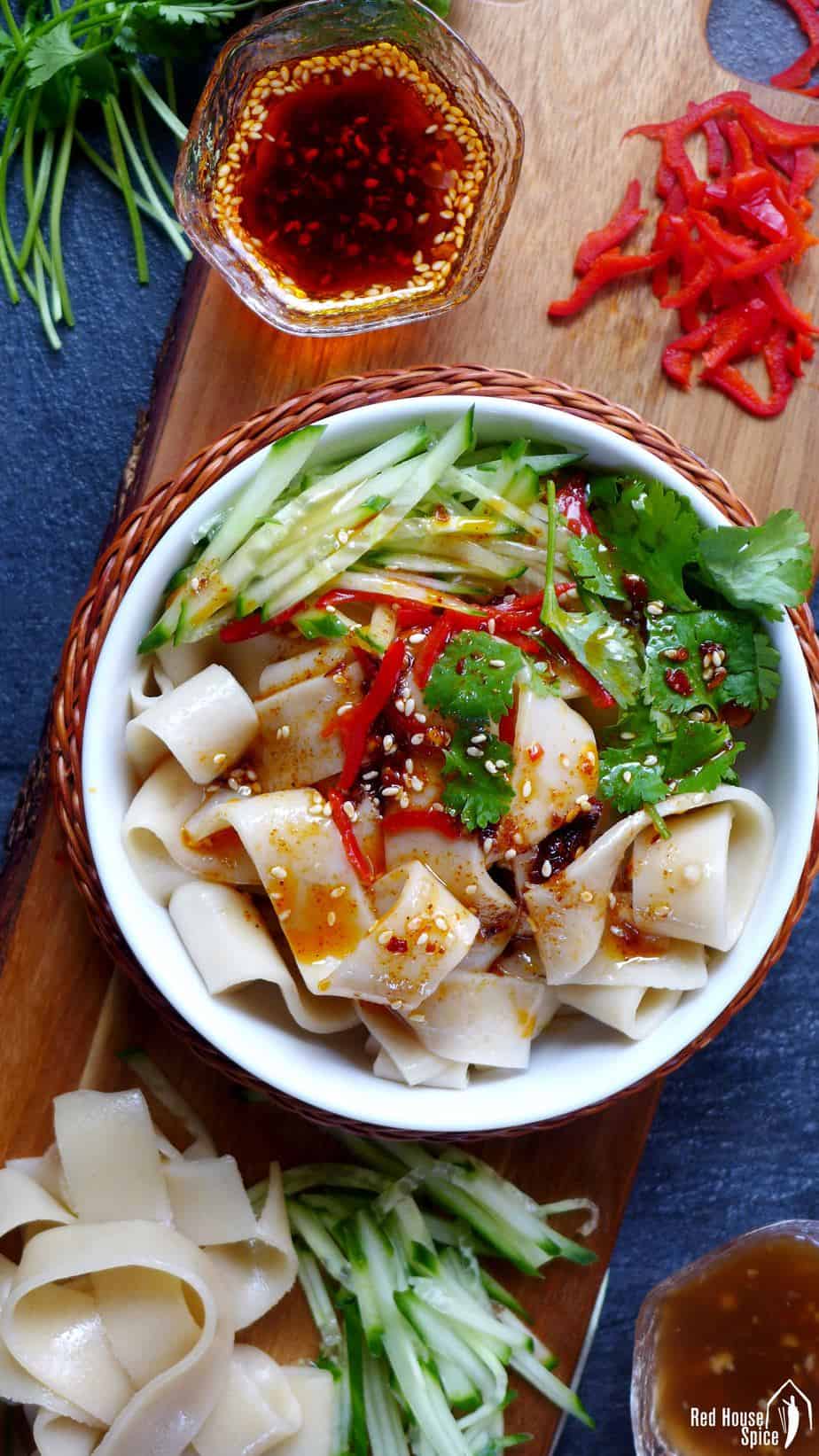A bowl of Liang Pi, cold skin noodles with fresh chilli & chilli oil on the side.