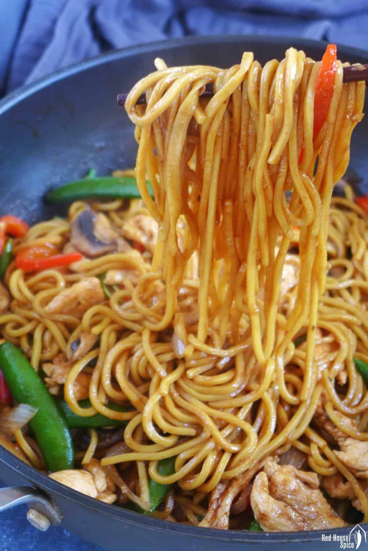 pulling lo mein noodles with chopsticks.