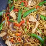 egg noodles, vegetables and chicken in a wok with overlay text that says Chinese Lo Mein.