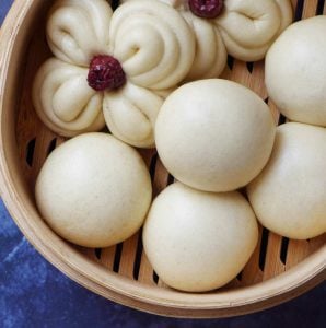 Chinese steamed buns in a bamboo basket.