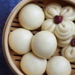 Chinese steamed buns in a bamboo basket.