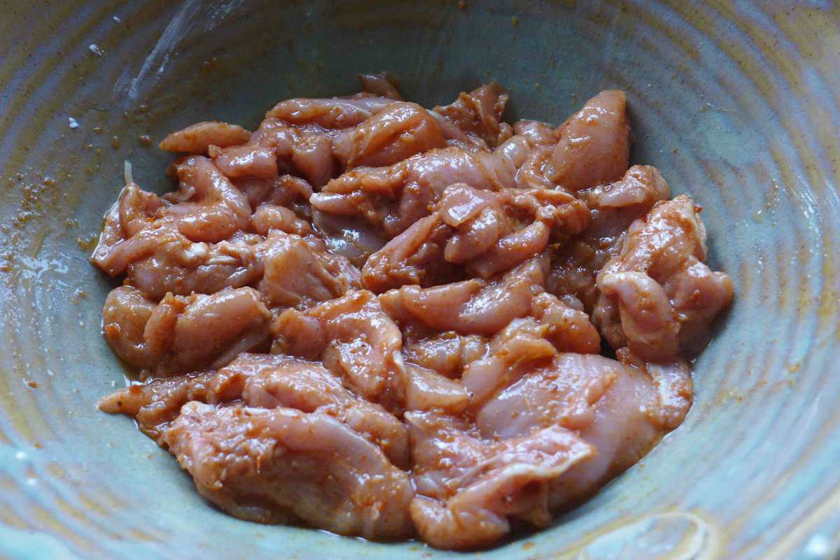 marinating chicken with seasonings.