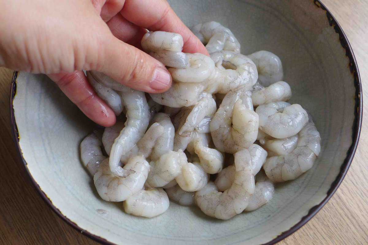 marinating shrimp with hand.