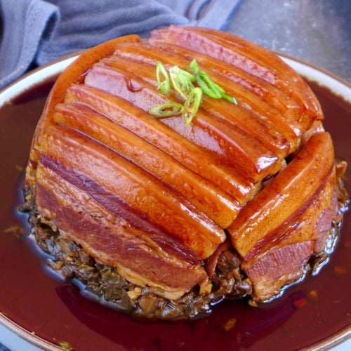 steamed pork belly over preserved mustard with sauce.