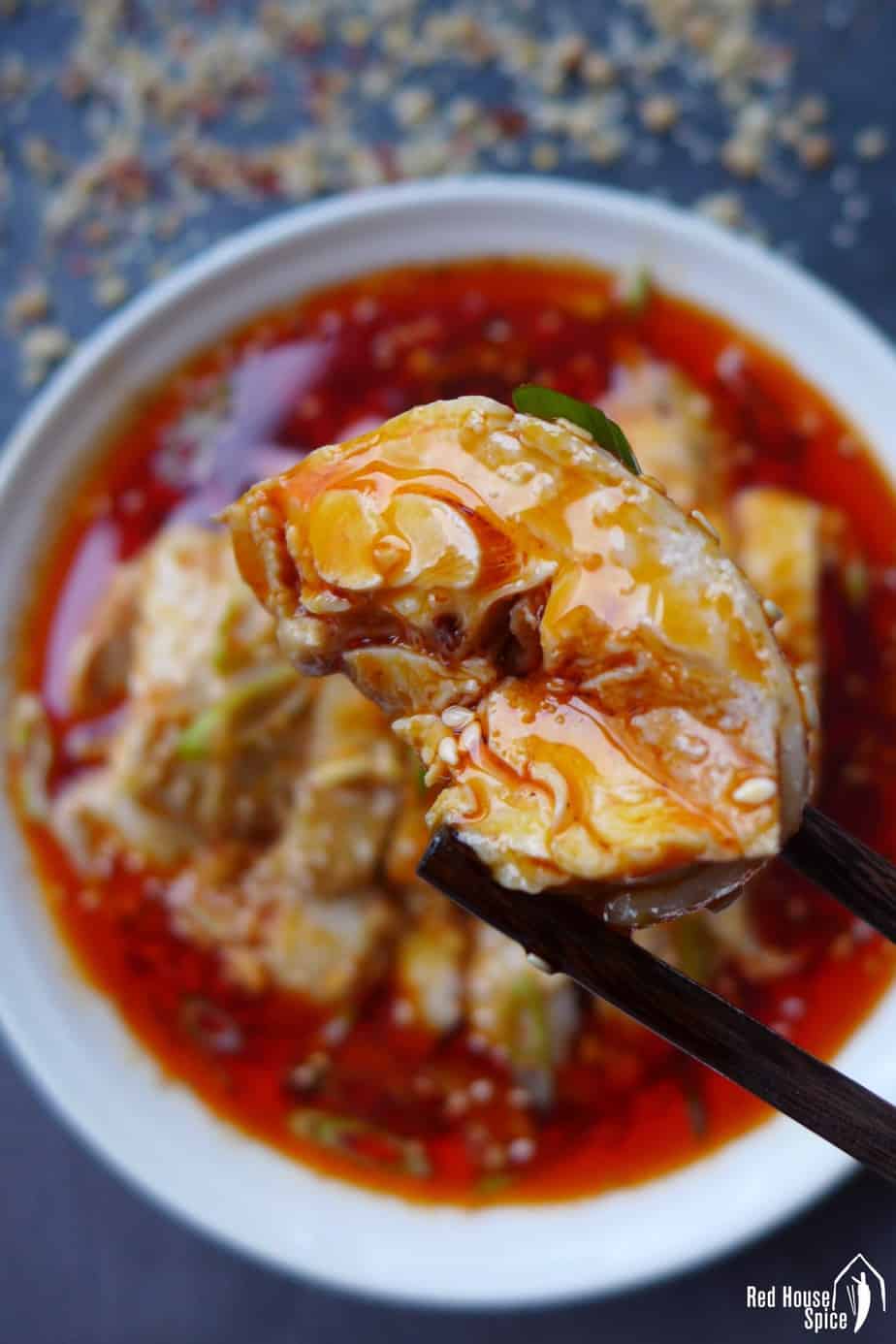 A piece of cold chicken seasoned with chilli oil