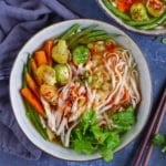 A bowl of noodle soup with turkey and vegetables