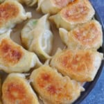 A plate of pan-fried pork and chive dumplings.