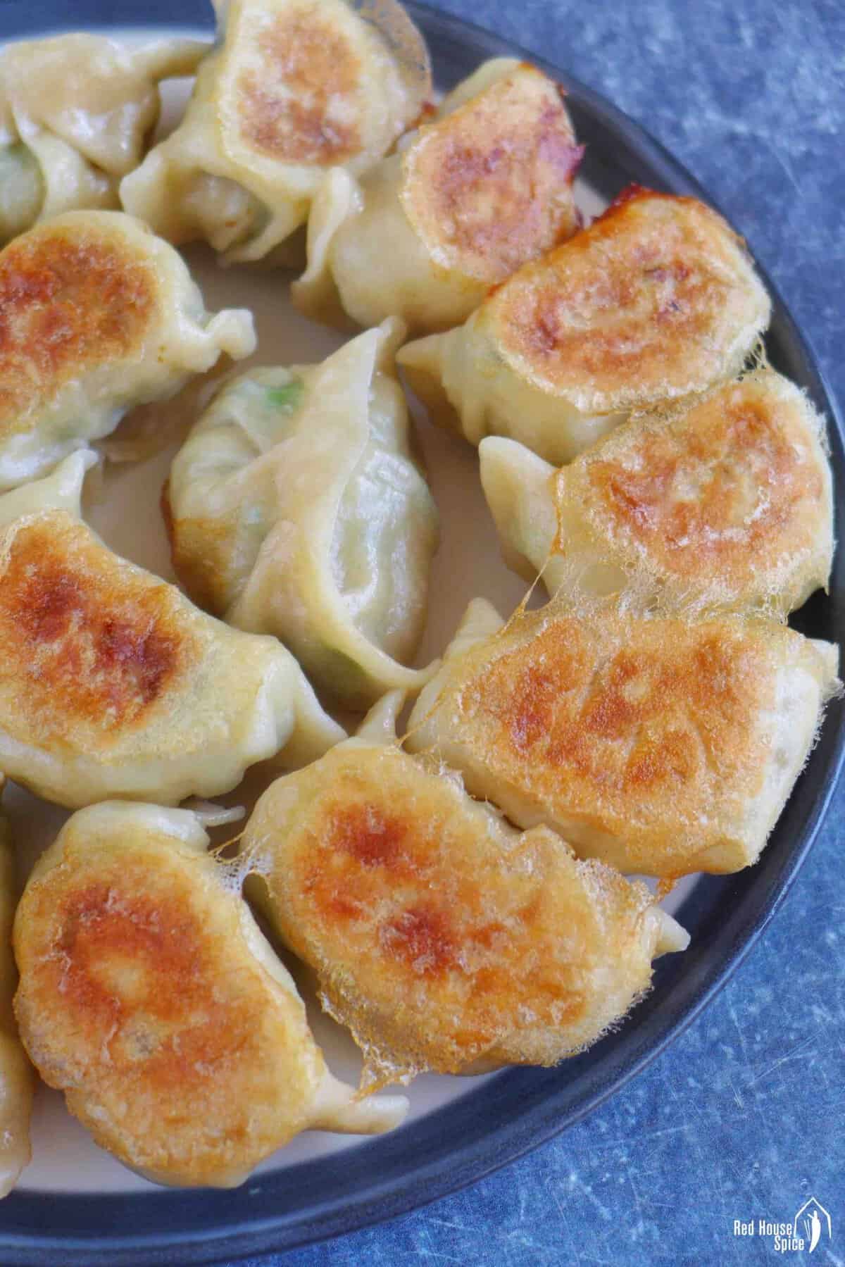A plate of pan-fried pork and chive dumplings.