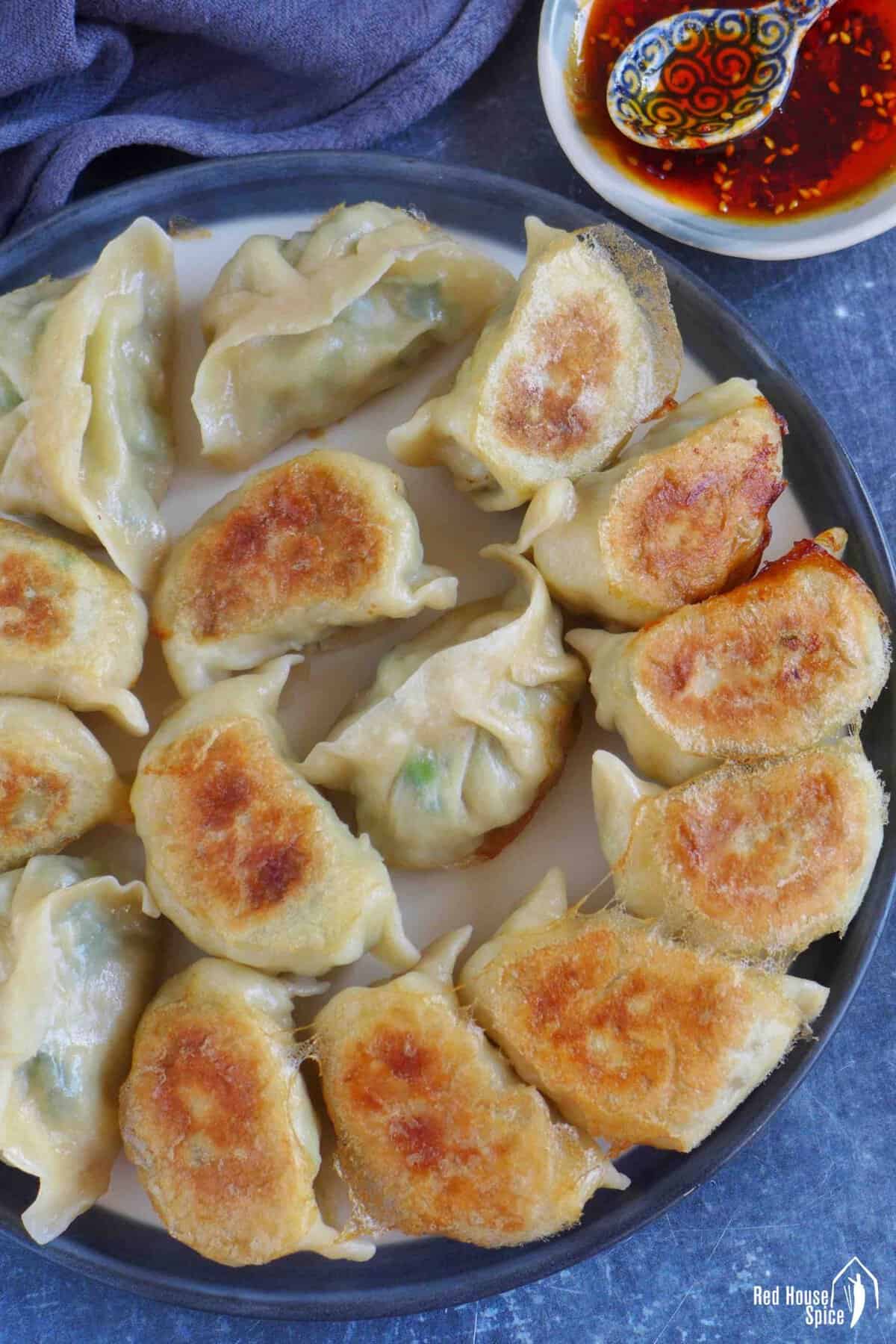 A plate of pan-fried pork and chive dumplings.
