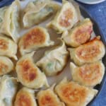 a plate of pork and chive dumplings with overlay text that says pan-fried dumplings.