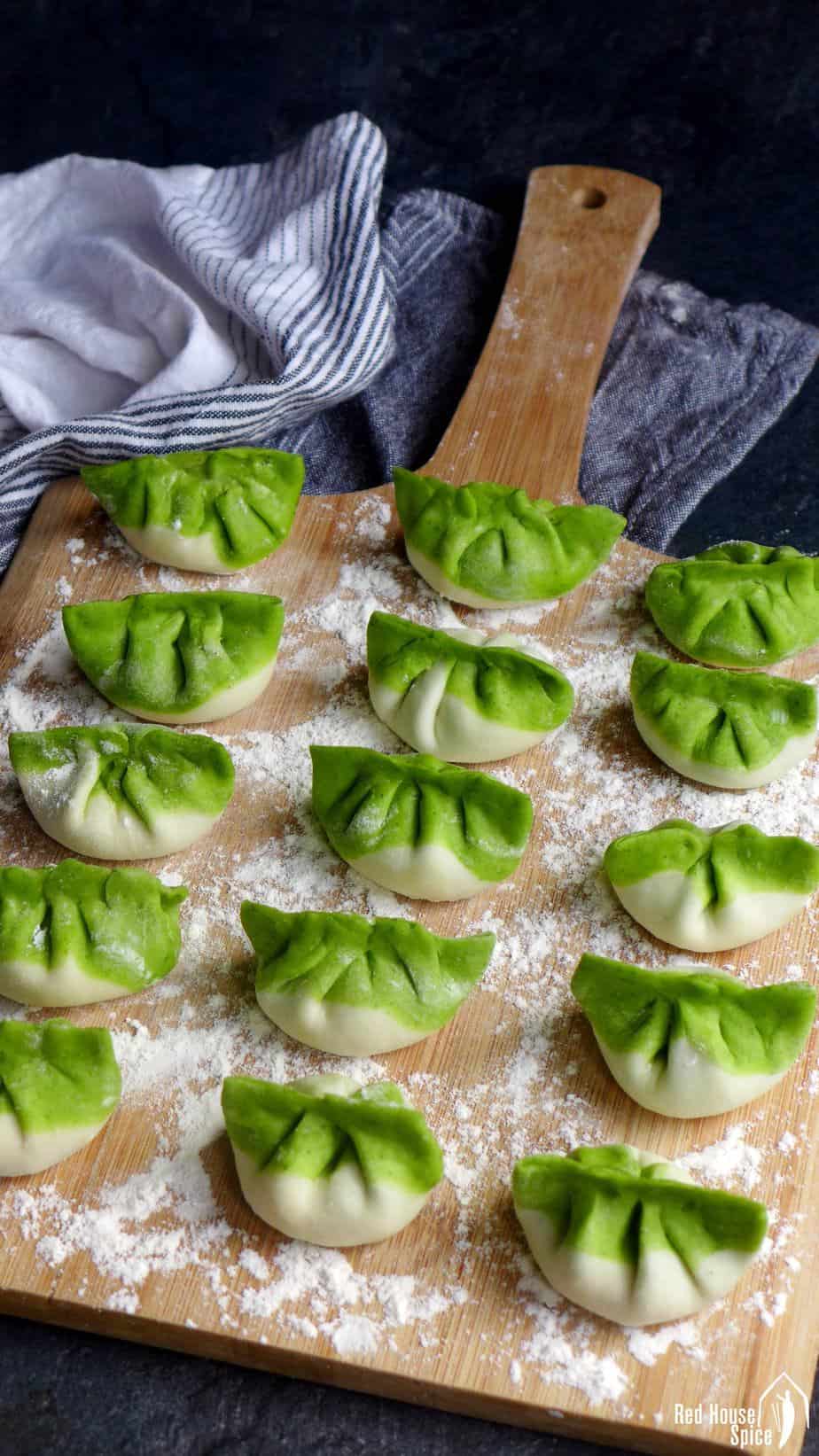 Uncooked vegetarian dumplings on a chopping board