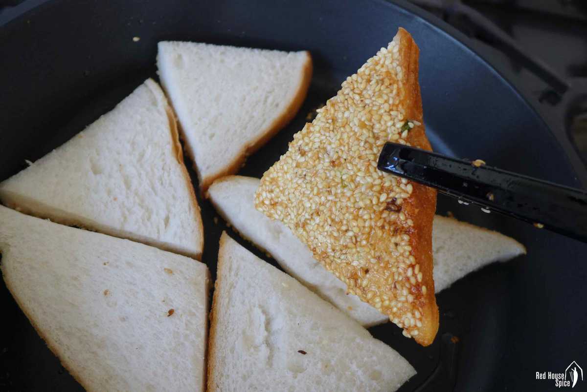 pan-frying toast covered with shrimp and sesame seeds.
