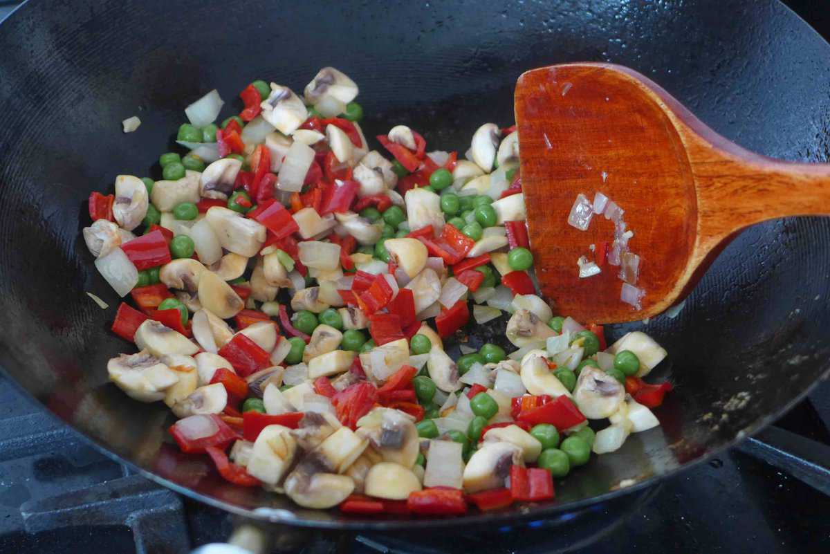 stir-frying mushroom, pepper and peas.