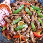 Stir-frying pepper steak in a wok.