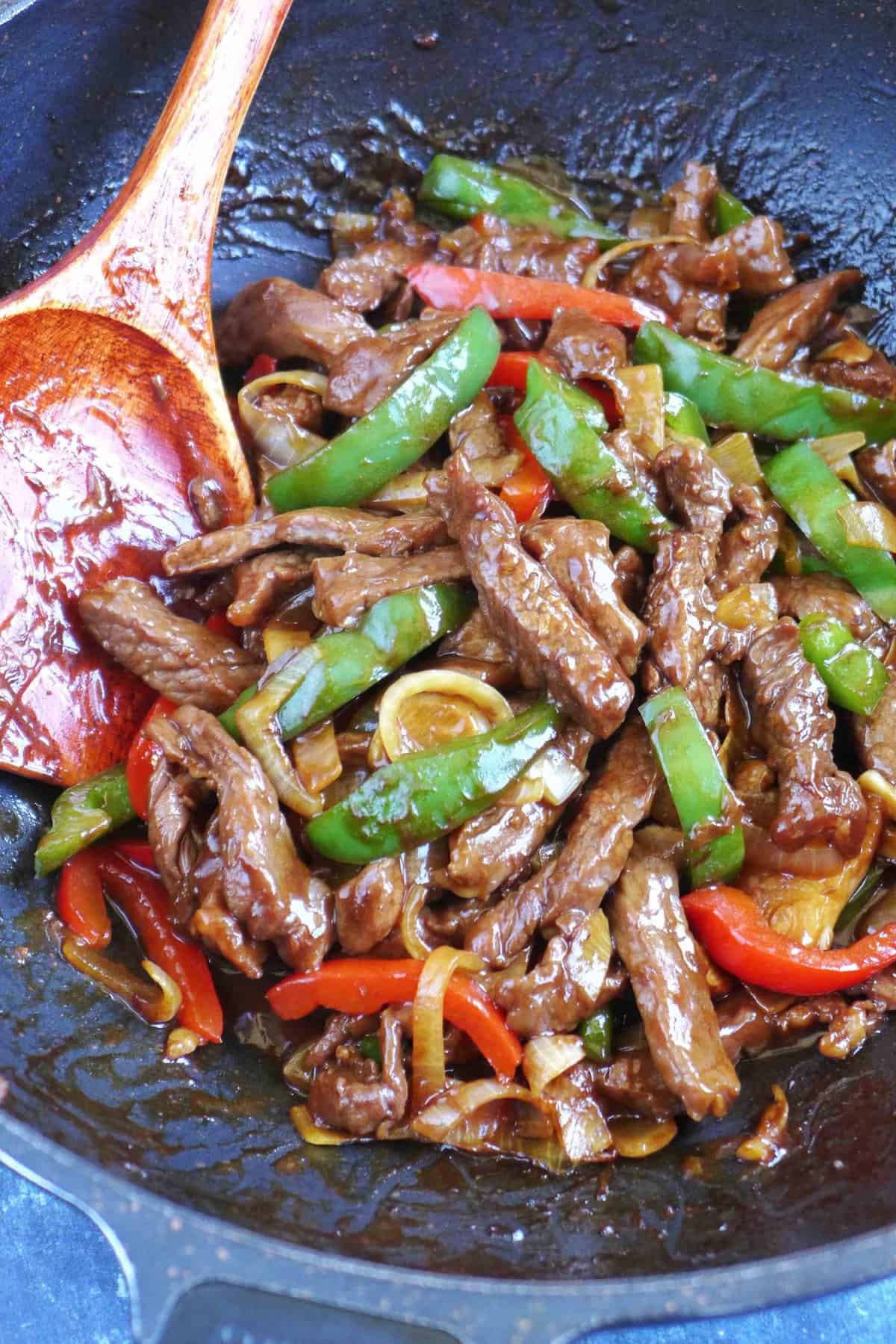 Stir-frying pepper steak in a wok.