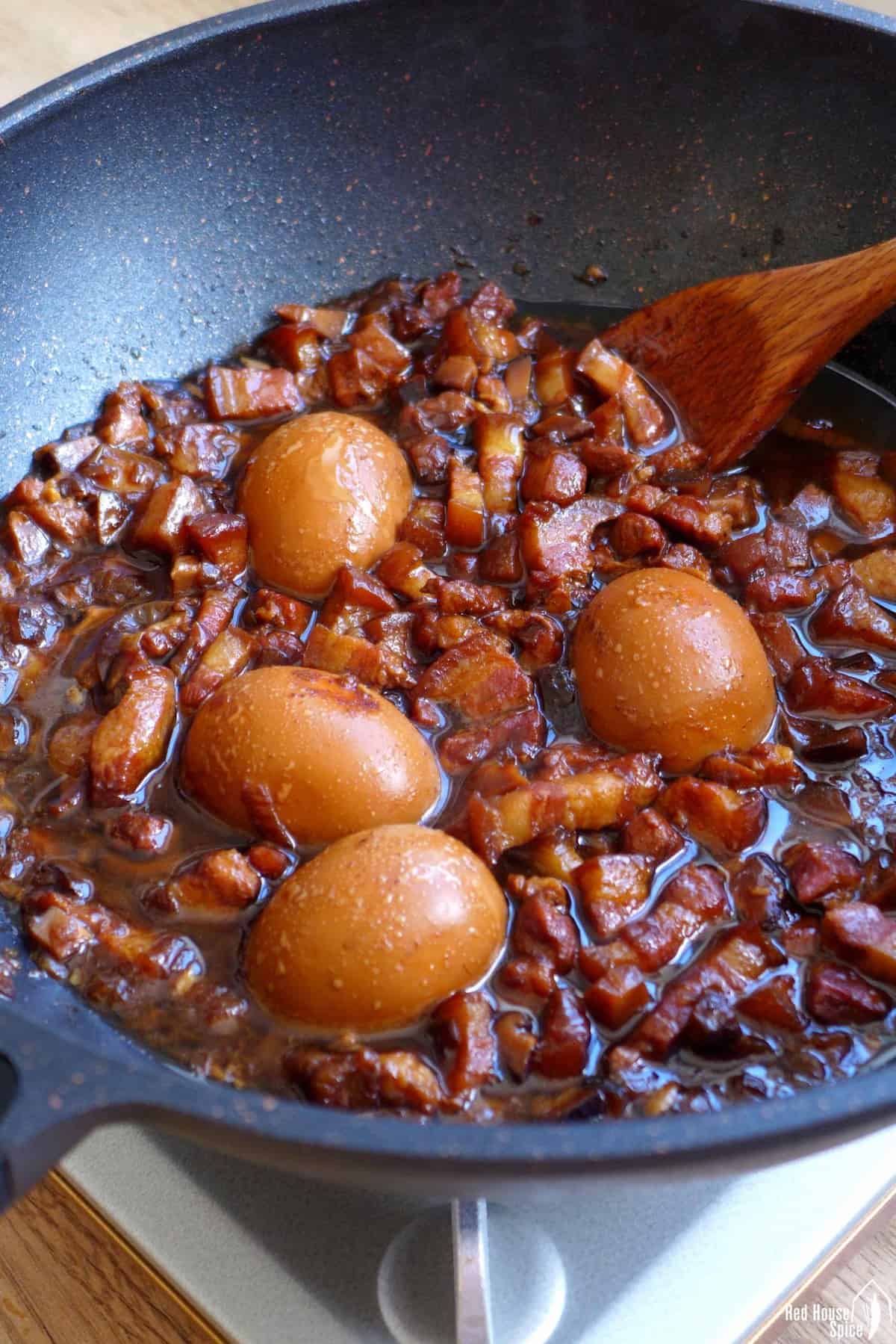 braised pork and eggs in a wok