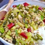 Pork and sour vegetable stir-fry over a bowl of rice.