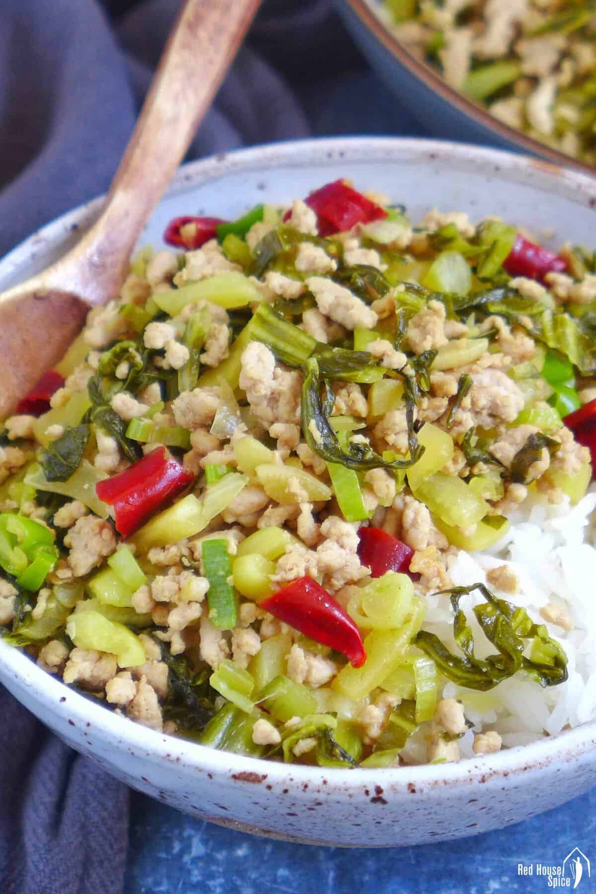 Pork and sour vegetable stir-fry over a bowl of rice.