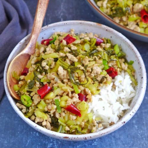 Pork and sour vegetable stir-fry over a bowl of rice.