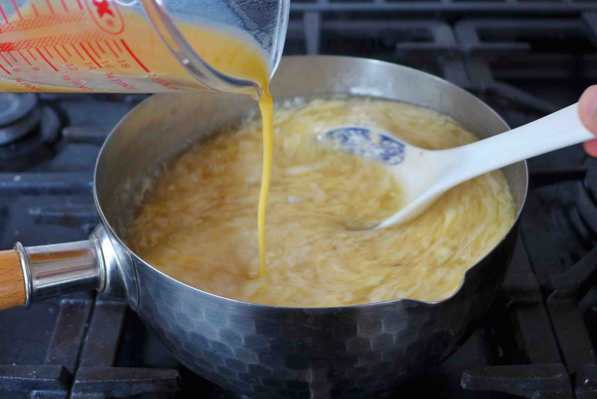 pouring beaten eggs to soup.