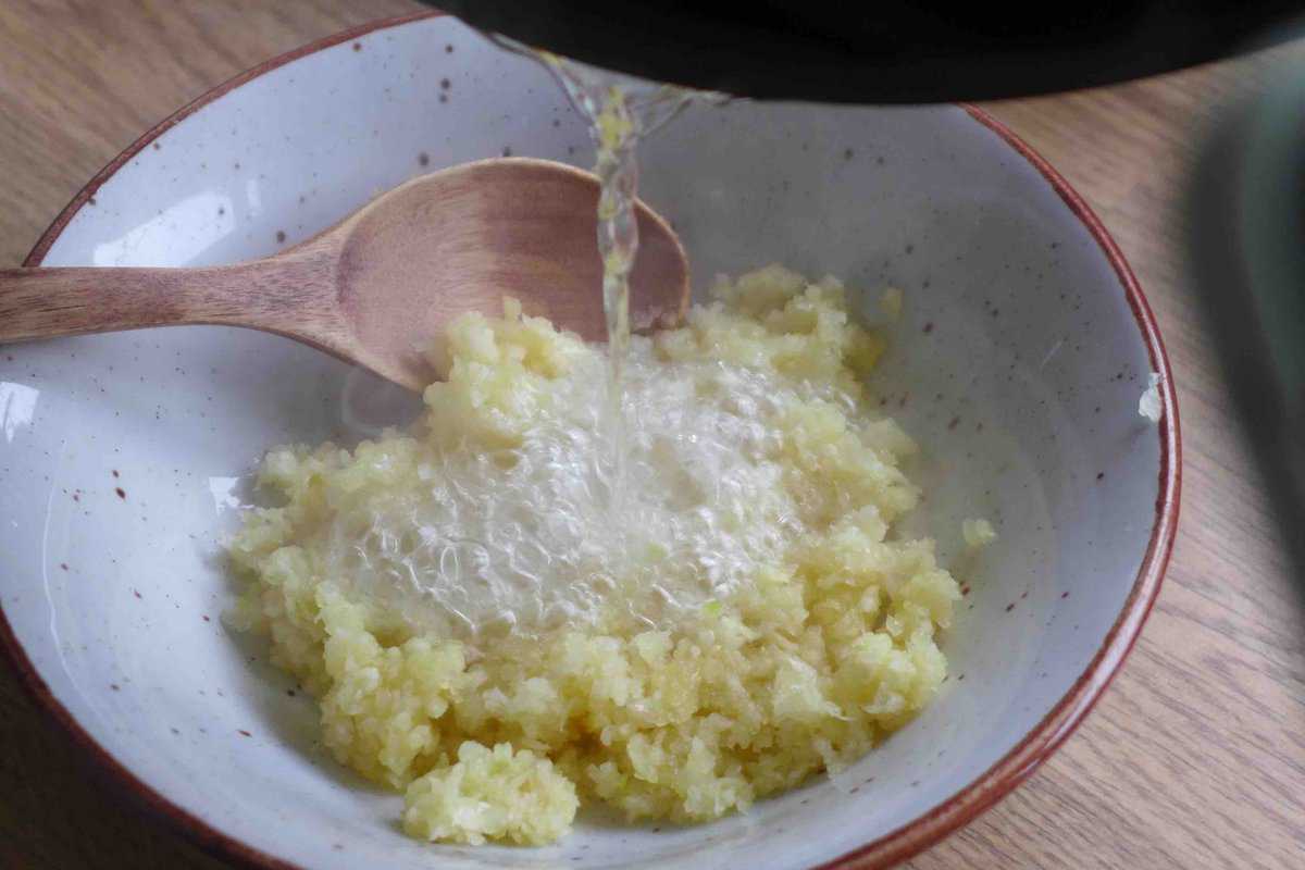 pouring hot oil over minced garlic.