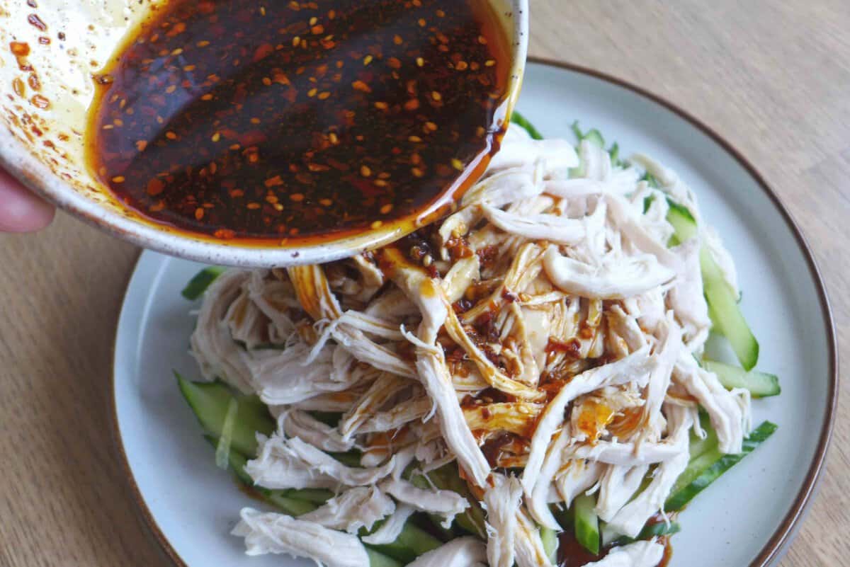 pouring sauce over chicken and cucumber.
