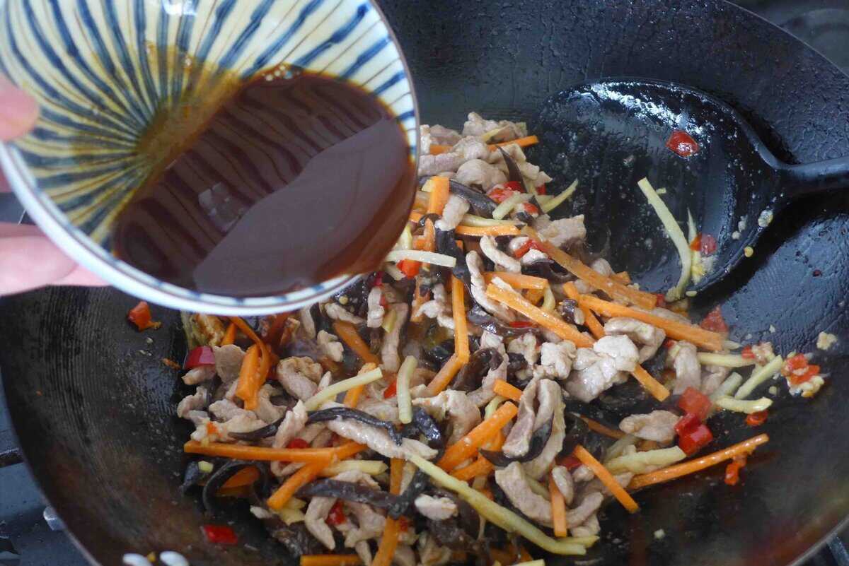 pouring sauce over pork and vegetables.
