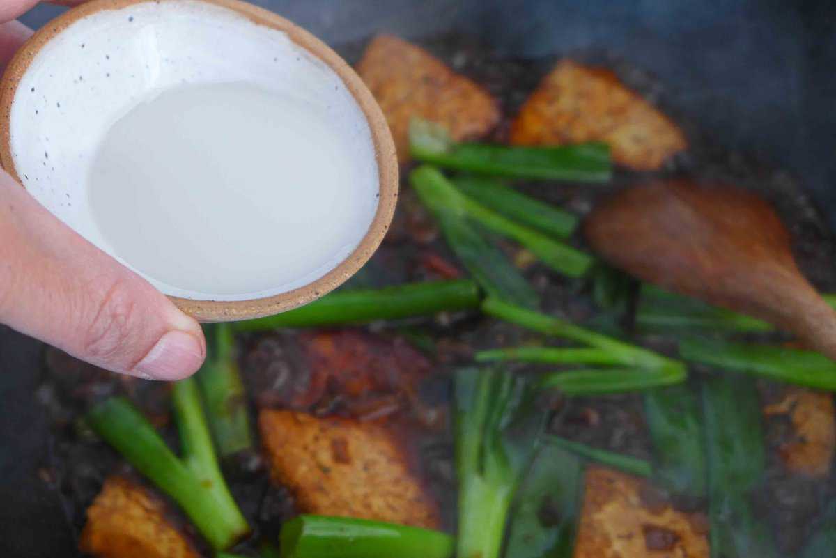 pouring starch slurry over tofu and scallions.