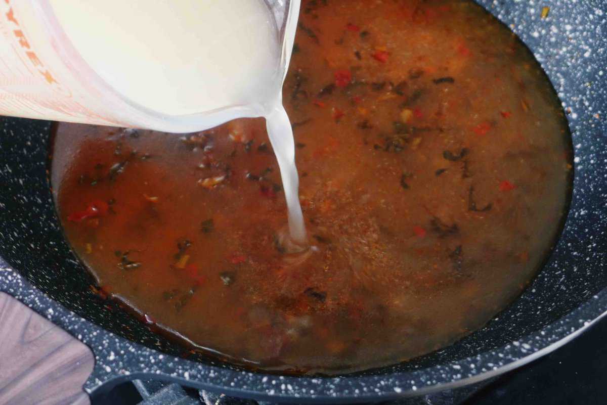 pouring stock into a wok.