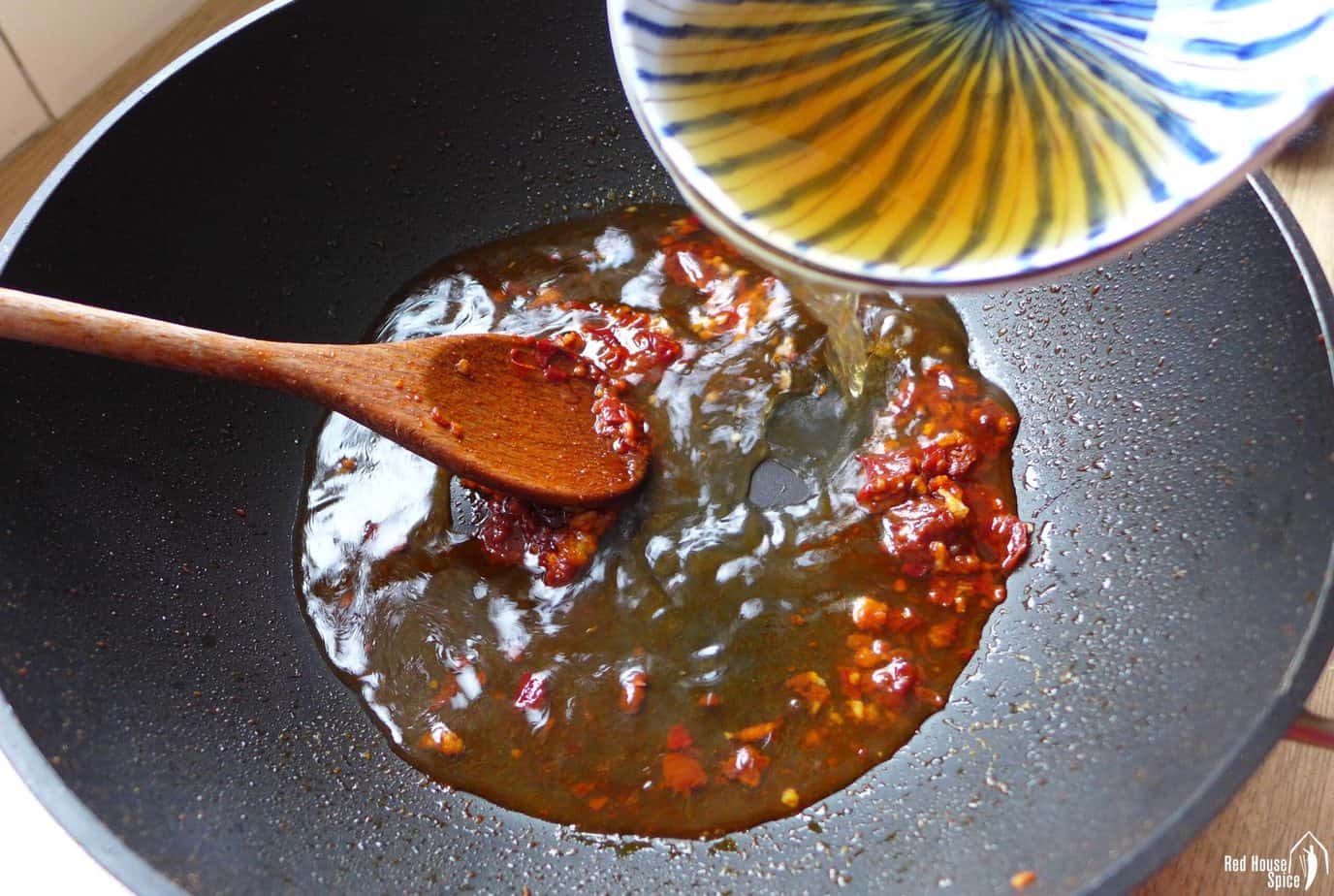 pouring liquid into a wok