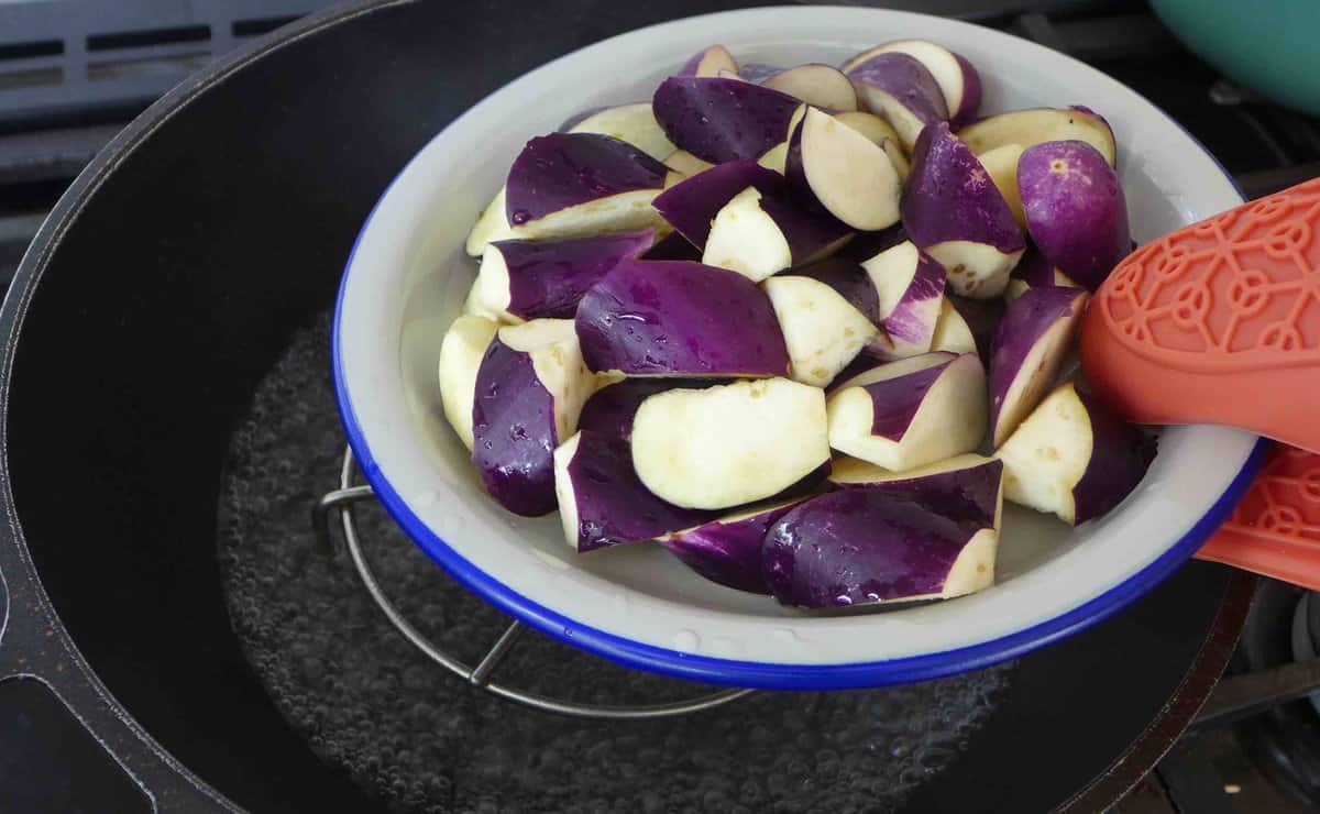 putting eggplant into a steamer.