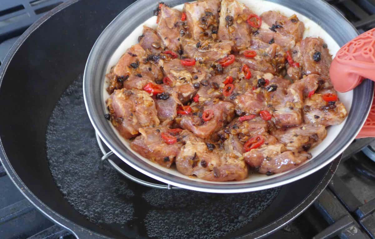 put a plate of marinated ribs into a steamer.