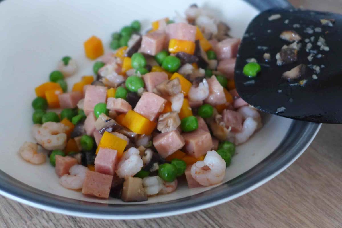 transferring cooked veggies and meat to a plate.