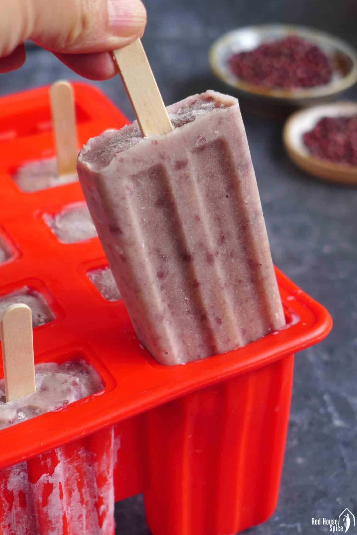 Pulling a red bean popsicle out of a mold.