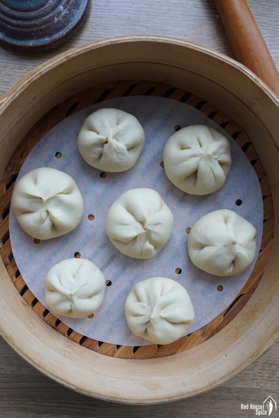 Uncooked Char Siu Bao inside a bamboo steamer