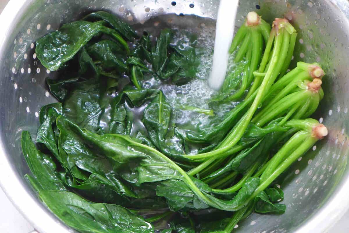 rinsing cooked spinach.