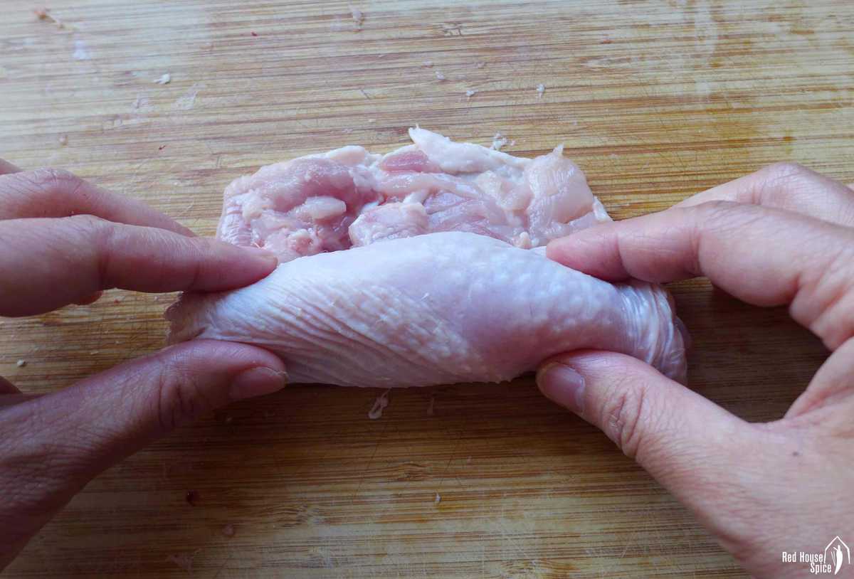 rolling a piece of deboned chicken