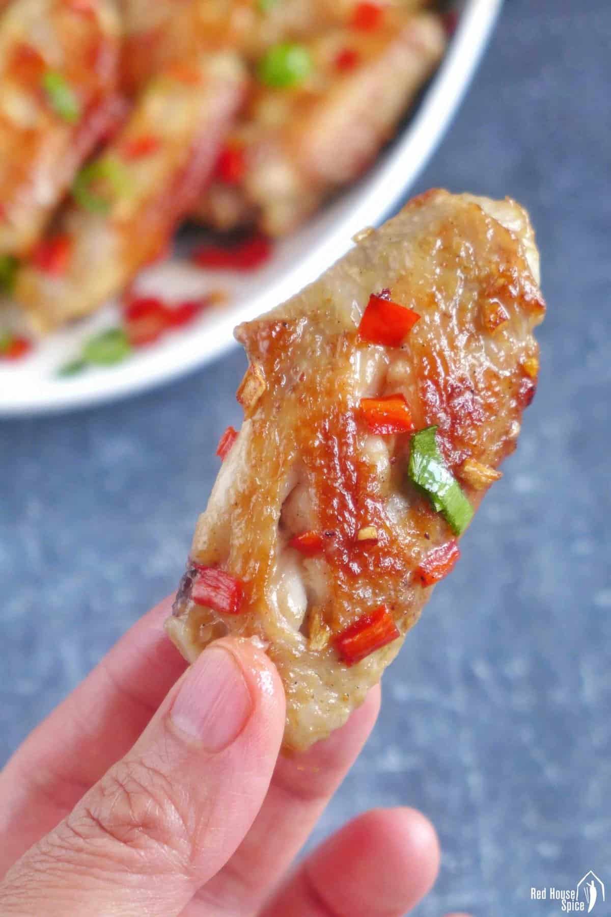 a chicken wing held by hand.