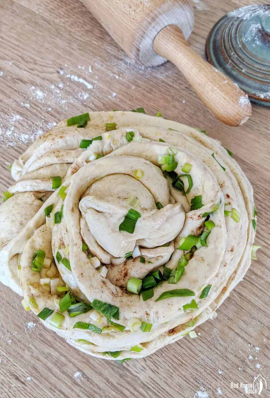 A piece of bread dough garnished with scallions
