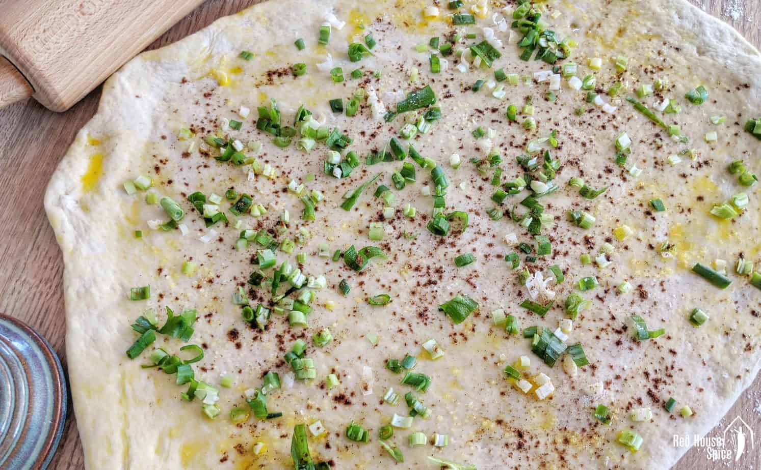 Flat dough covered with scallions, oil and spices.