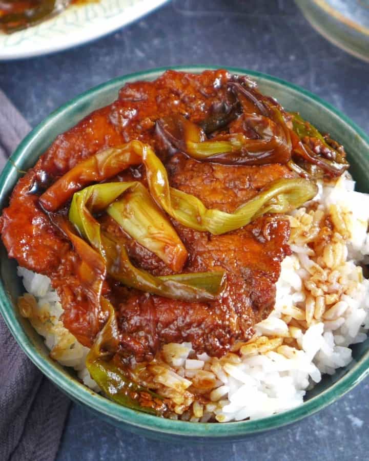 scallion pork chop over a bowl of rice.